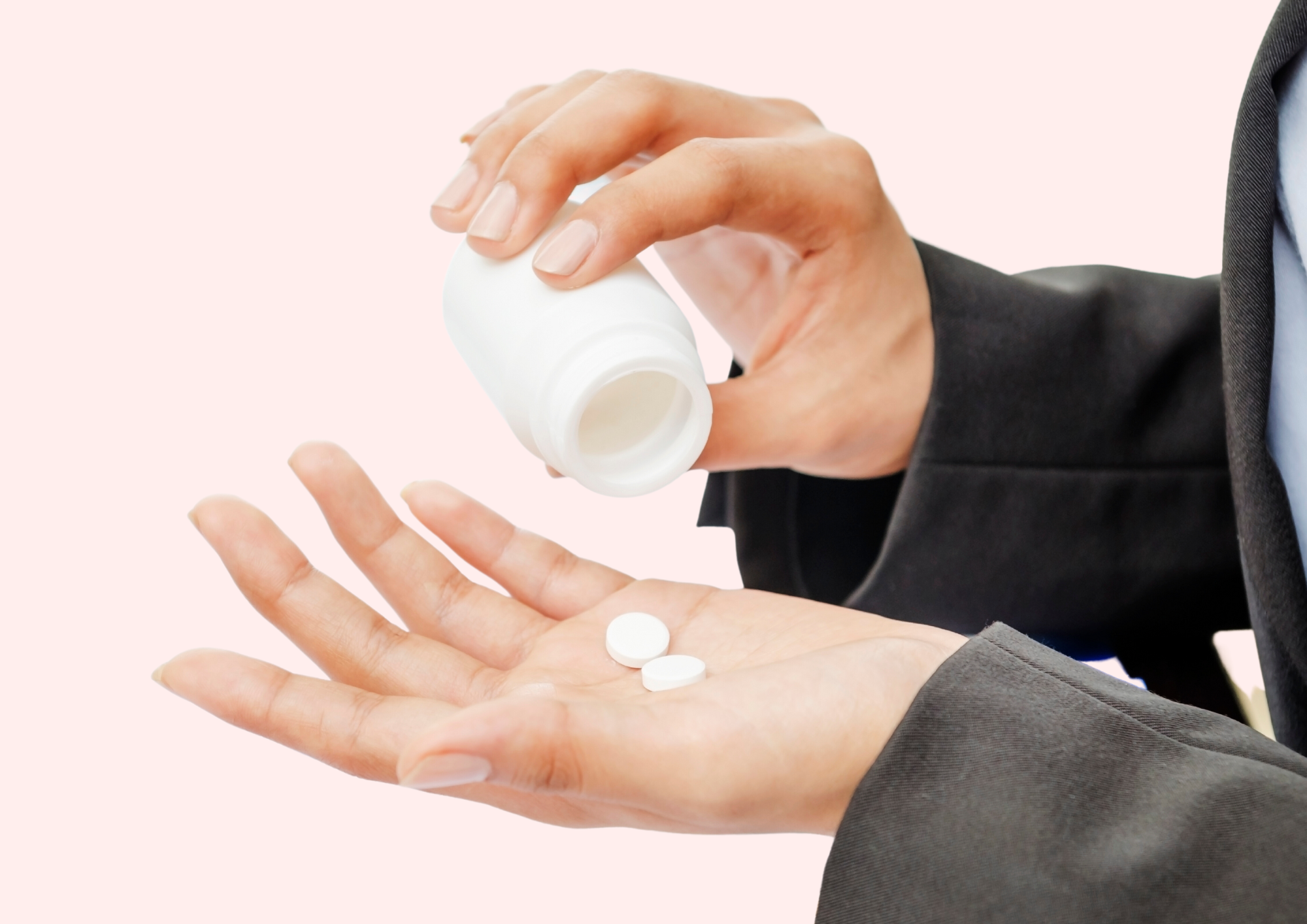 Woman holds pain killer pills in her hands.