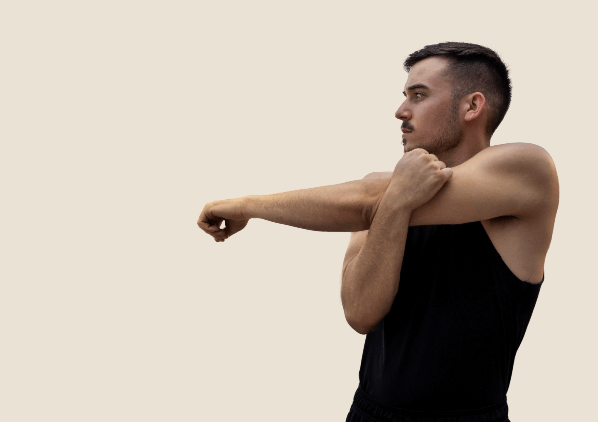 Man in black shirt is stretching his arm and shoulder. Beige Background.
