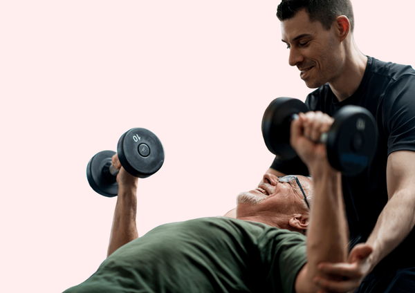 Physiotherapist helps elderly patient with weighted exercise.